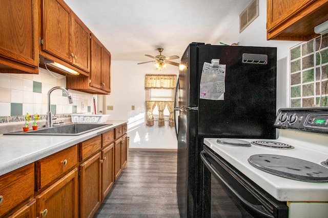 kitchen with dark wood-type flooring, sink, a healthy amount of sunlight, and electric range