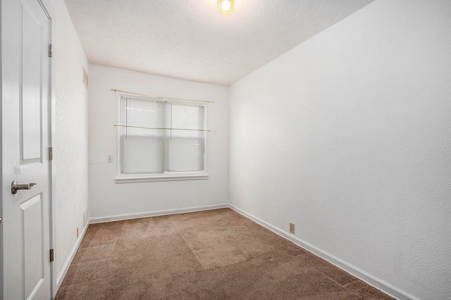 carpeted empty room with a textured ceiling