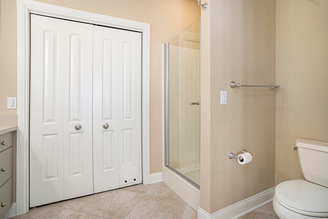 bathroom with vanity, walk in shower, tile patterned floors, and toilet