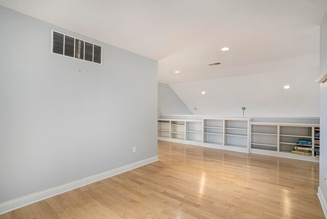 unfurnished living room featuring light hardwood / wood-style floors and vaulted ceiling