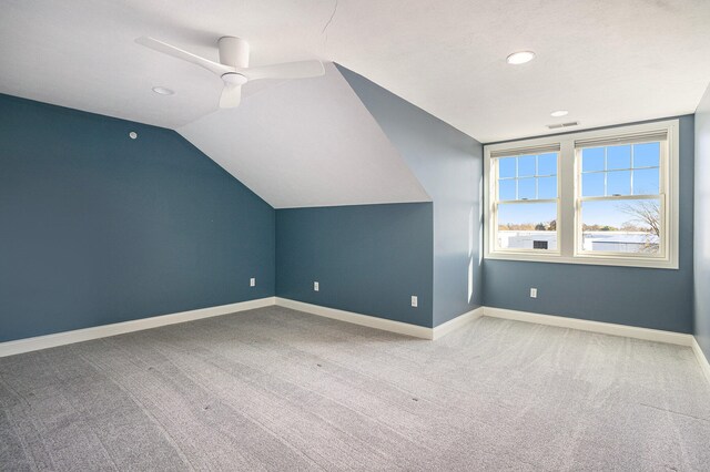 additional living space featuring ceiling fan, light colored carpet, and vaulted ceiling