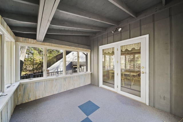 unfurnished sunroom featuring vaulted ceiling with beams