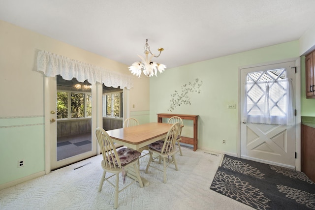 dining room with a chandelier and light carpet