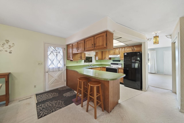 kitchen with kitchen peninsula, black fridge, white range with electric cooktop, and light carpet