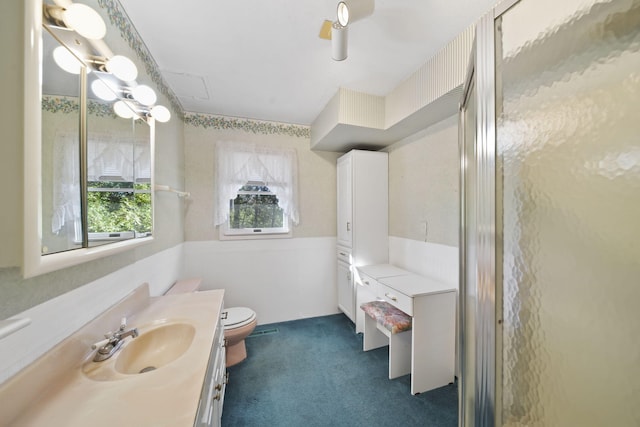 bathroom featuring walk in shower, vanity, and toilet