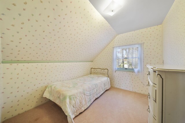 bedroom featuring light colored carpet and vaulted ceiling