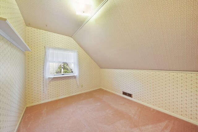 bonus room featuring carpet flooring, a textured ceiling, and vaulted ceiling