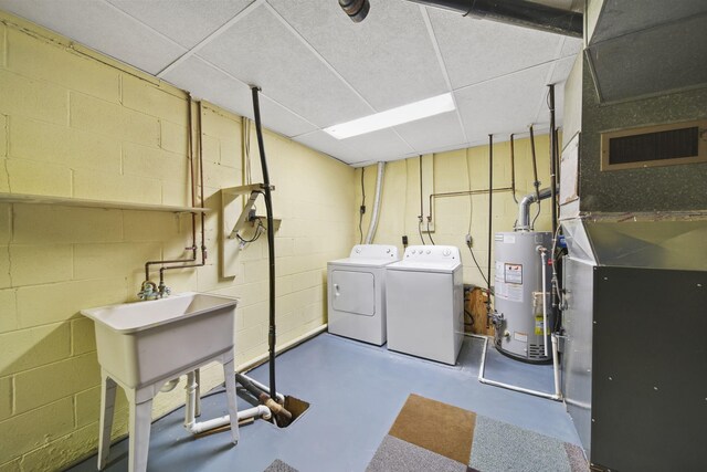 clothes washing area with heating unit, gas water heater, and separate washer and dryer