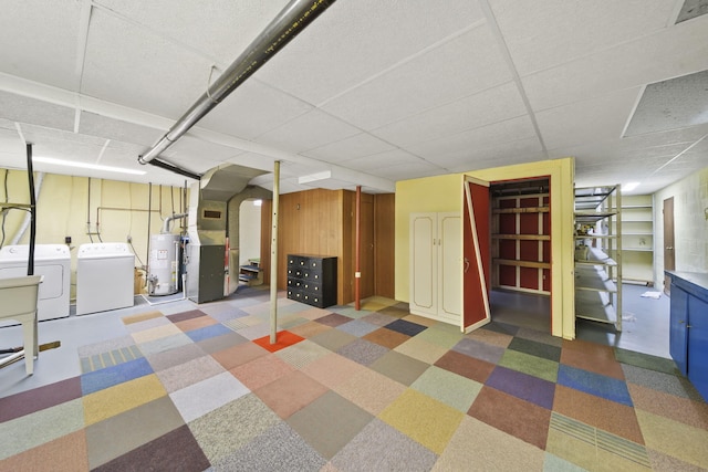 basement with a drop ceiling, separate washer and dryer, and water heater