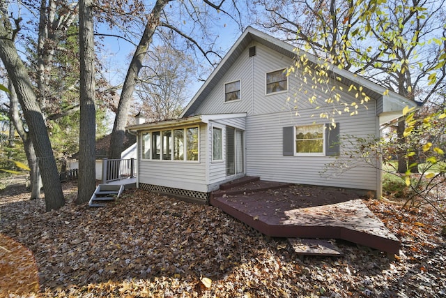 rear view of house featuring a sunroom and a wooden deck