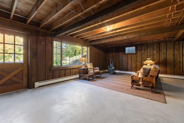 interior space with wooden walls, concrete floors, and a baseboard radiator