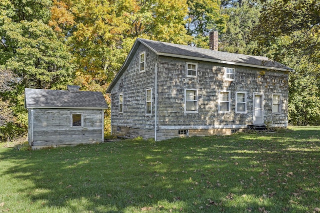 view of side of home featuring an outbuilding and a yard