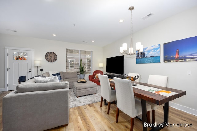 dining area featuring light hardwood / wood-style floors and an inviting chandelier