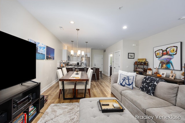 living room featuring a chandelier and light hardwood / wood-style floors