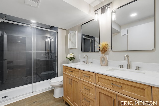 bathroom featuring hardwood / wood-style flooring, vanity, toilet, and walk in shower