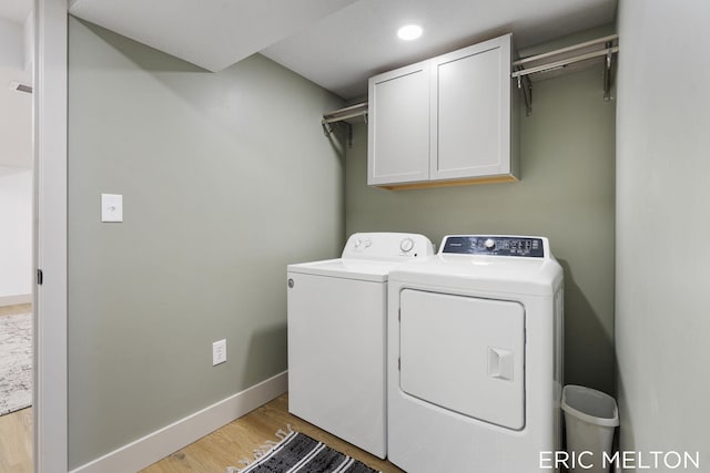 laundry area with light hardwood / wood-style floors, cabinets, and washing machine and clothes dryer