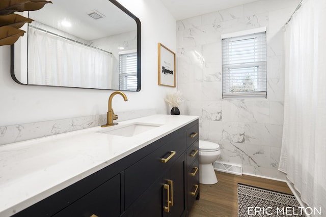 bathroom featuring hardwood / wood-style flooring, vanity, toilet, and walk in shower