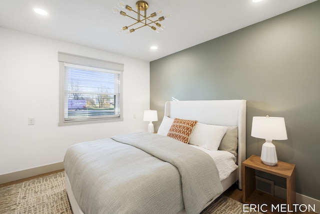 bedroom featuring an inviting chandelier and hardwood / wood-style flooring