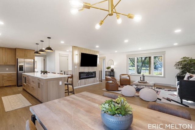 dining space with a notable chandelier and light hardwood / wood-style flooring