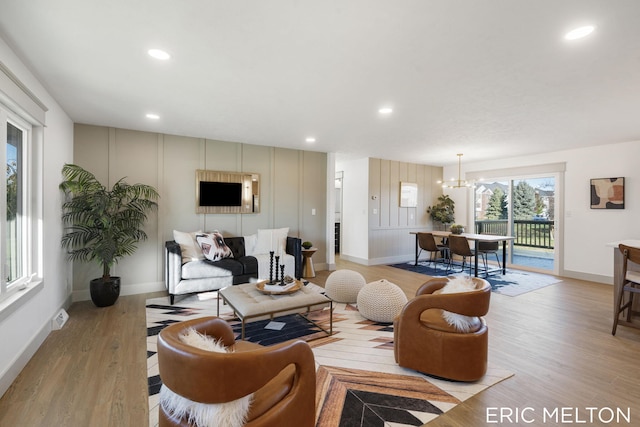 living room with light hardwood / wood-style floors and an inviting chandelier