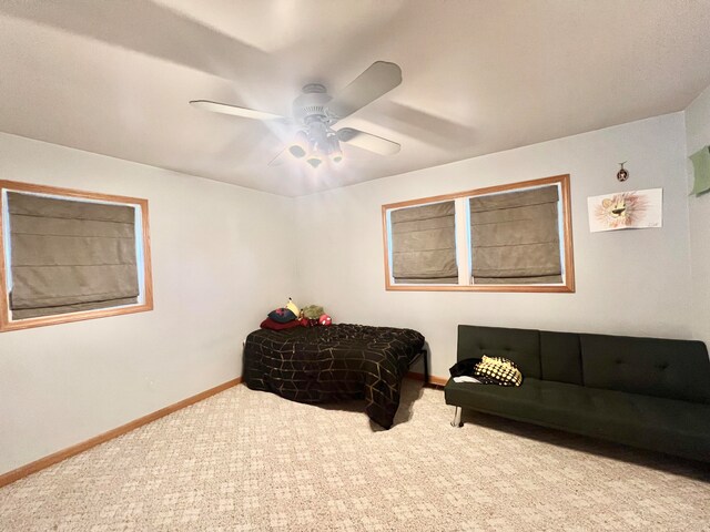 living area featuring carpet and ceiling fan