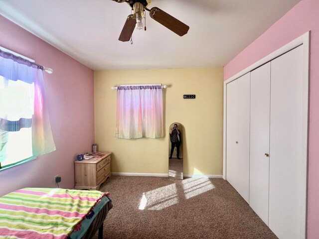 carpeted bedroom with ceiling fan and a closet