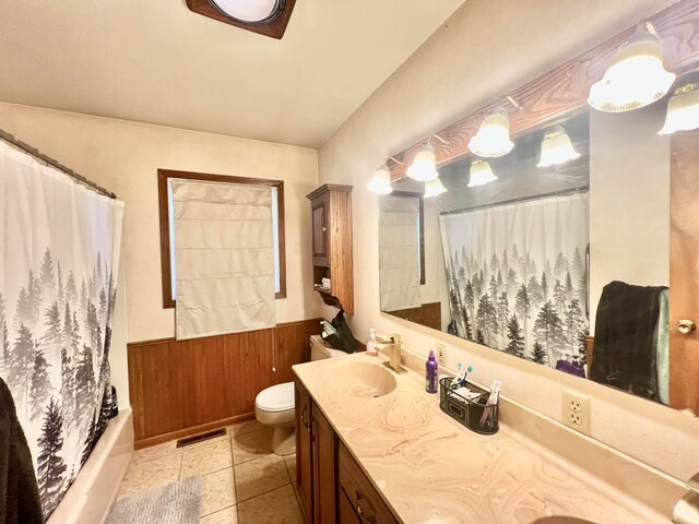 full bathroom featuring vanity, shower / bath combo with shower curtain, tile patterned flooring, toilet, and wood walls