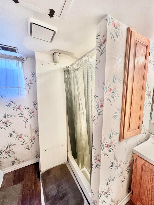 bathroom with hardwood / wood-style flooring, vanity, and walk in shower