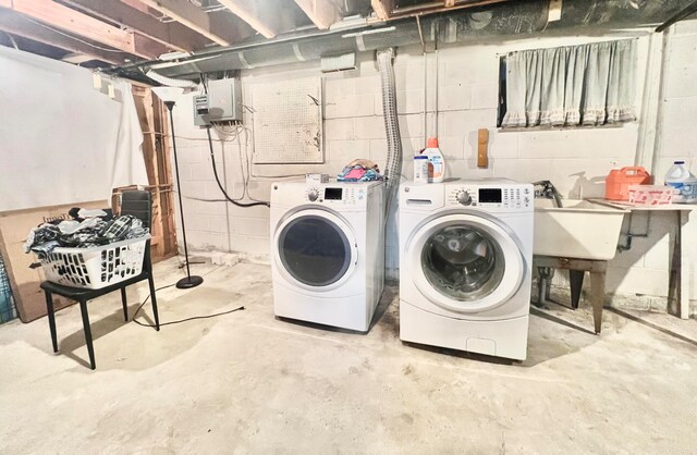 clothes washing area with washer and clothes dryer and sink