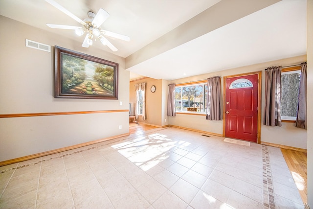 foyer entrance with ceiling fan and light tile patterned floors