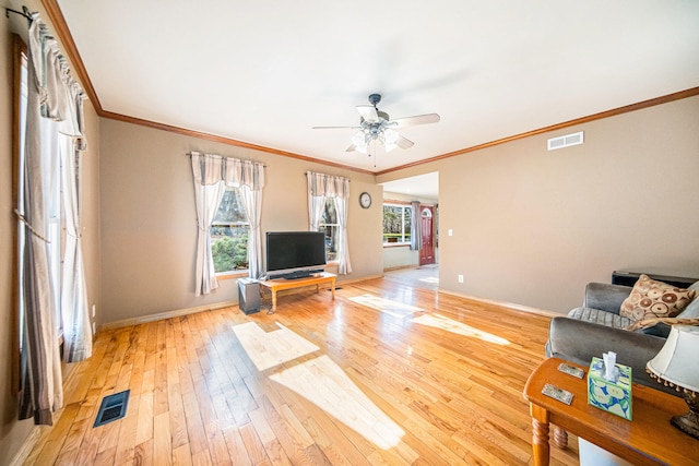 unfurnished living room with crown molding, a wealth of natural light, light hardwood / wood-style floors, and ceiling fan