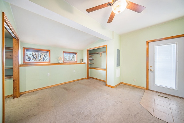 interior space featuring ceiling fan, light colored carpet, multiple windows, and lofted ceiling