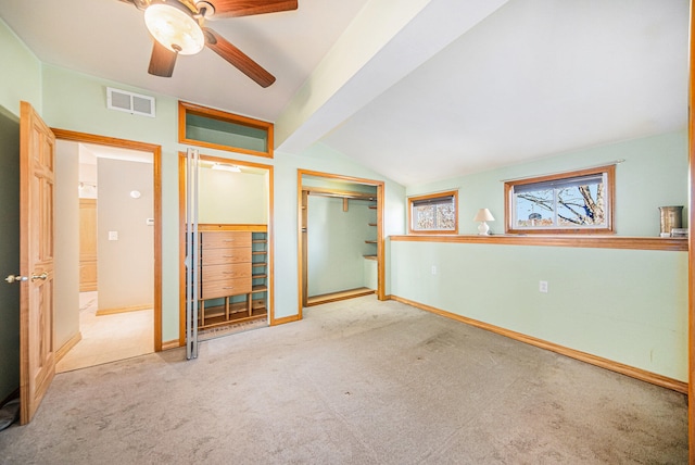 carpeted spare room featuring ceiling fan and vaulted ceiling