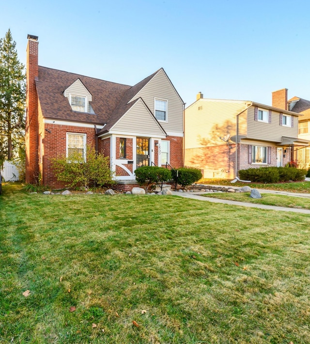 cape cod house with a front lawn