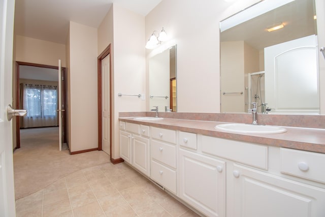 bathroom with tile patterned floors, vanity, and a shower with door