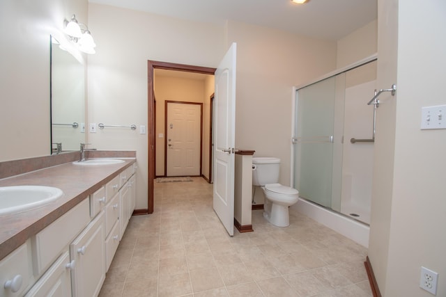 bathroom featuring vanity, tile patterned flooring, a shower with door, and toilet