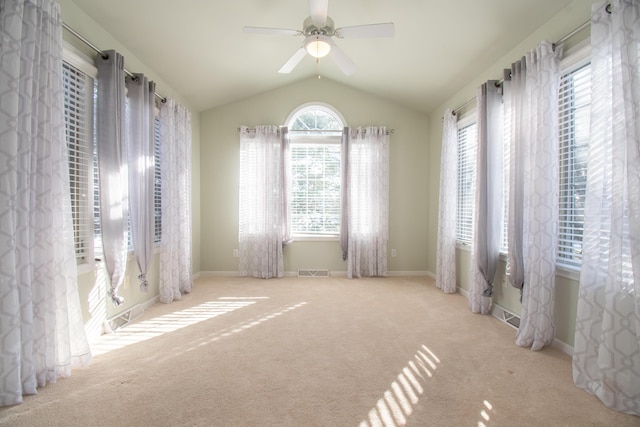 empty room with ceiling fan, lofted ceiling, and light carpet