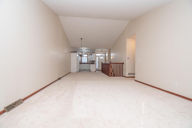 unfurnished living room with vaulted ceiling, carpet, and an inviting chandelier