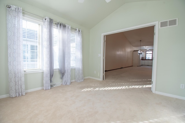 carpeted spare room with vaulted ceiling