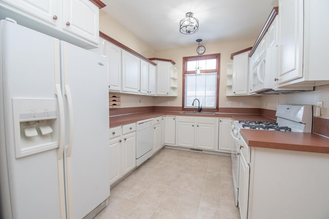 kitchen with white appliances, sink, and white cabinets