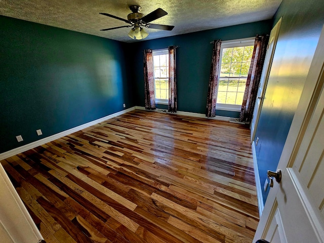 empty room with a textured ceiling, hardwood / wood-style flooring, and ceiling fan