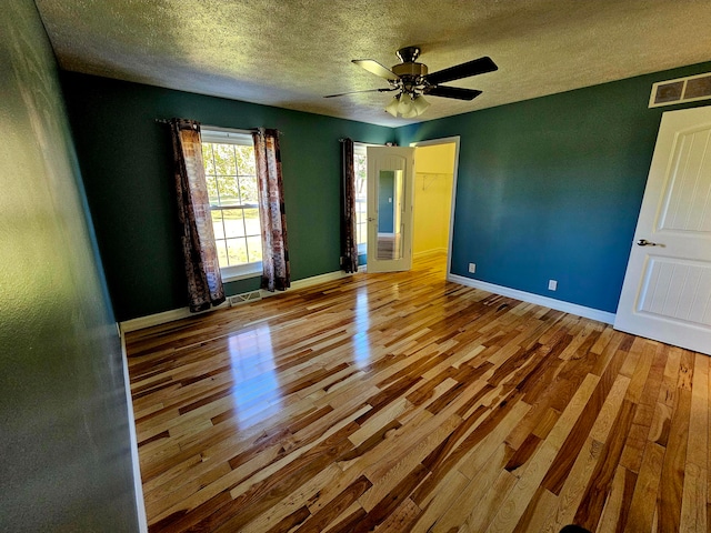 unfurnished room featuring a textured ceiling, wood-type flooring, and ceiling fan