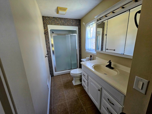 bathroom with walk in shower, vanity, a textured ceiling, tile patterned flooring, and toilet