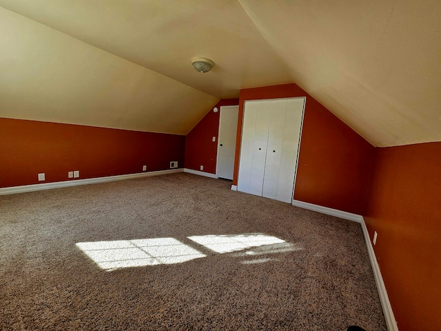 bonus room with vaulted ceiling and carpet floors