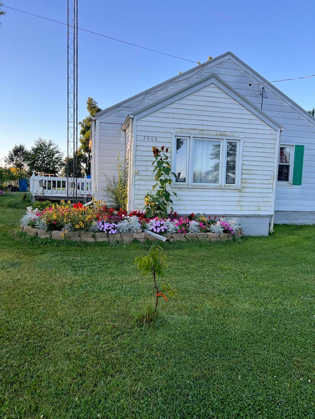 view of side of home with a yard and a deck