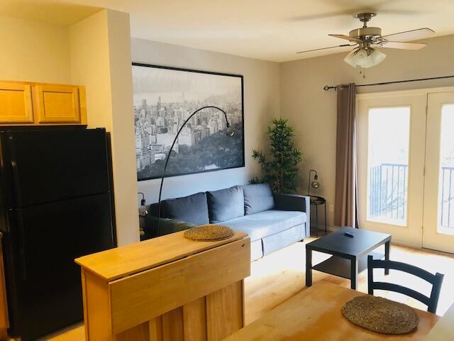 living room with light wood-type flooring and ceiling fan