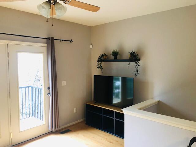 living room featuring light hardwood / wood-style flooring and ceiling fan