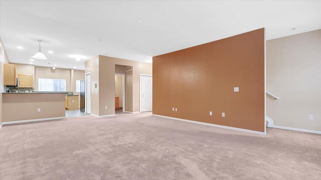 unfurnished living room with light colored carpet