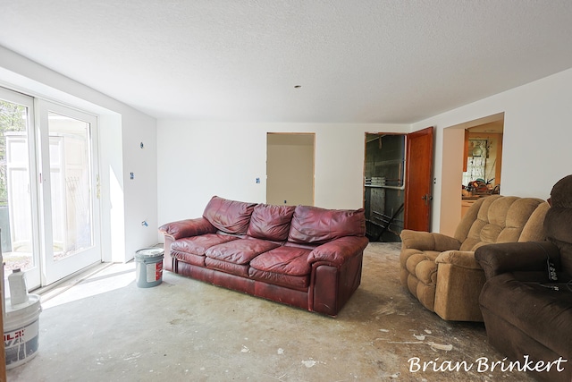 living room with a textured ceiling and concrete floors