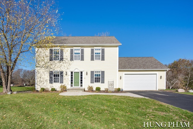 colonial inspired home featuring a front yard and a garage